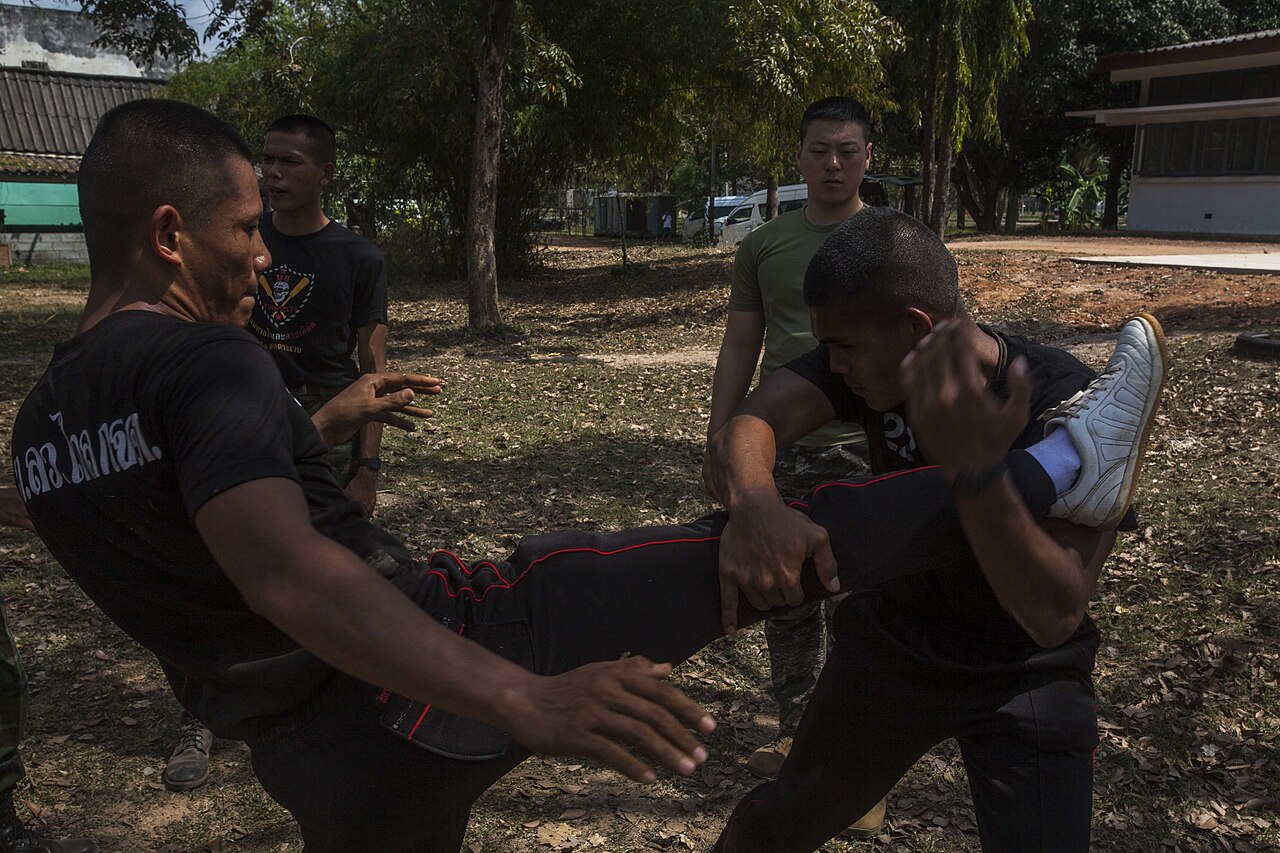 ทหารเรือไทยสาธิตการรับเตะ ผู้รับใช้แขนหนีบขาคู่ต่อสู้ไว้กับลำตัวขณะที่ผู้เตะเสียหลัก ในการฝึกร่วมคอบร้าโกลด์